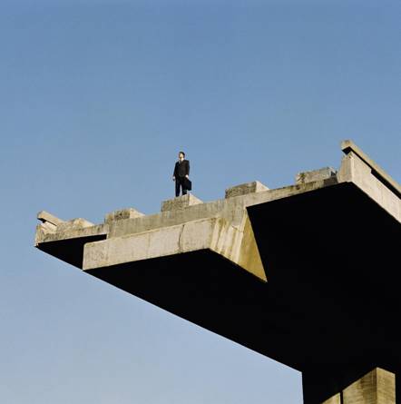 man standing on overpass bridge