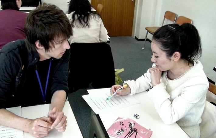 A caucasian student speaking with a Japanese person