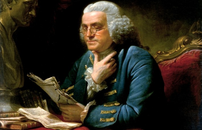 A painting of Benjamin Franklin looking at some notes