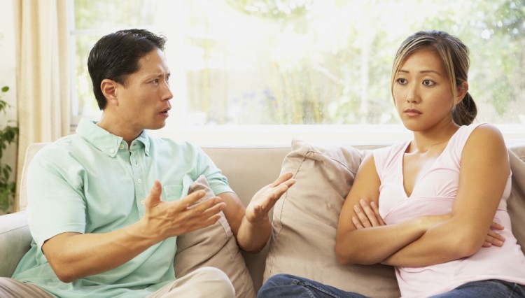 man and woman arguing on couch