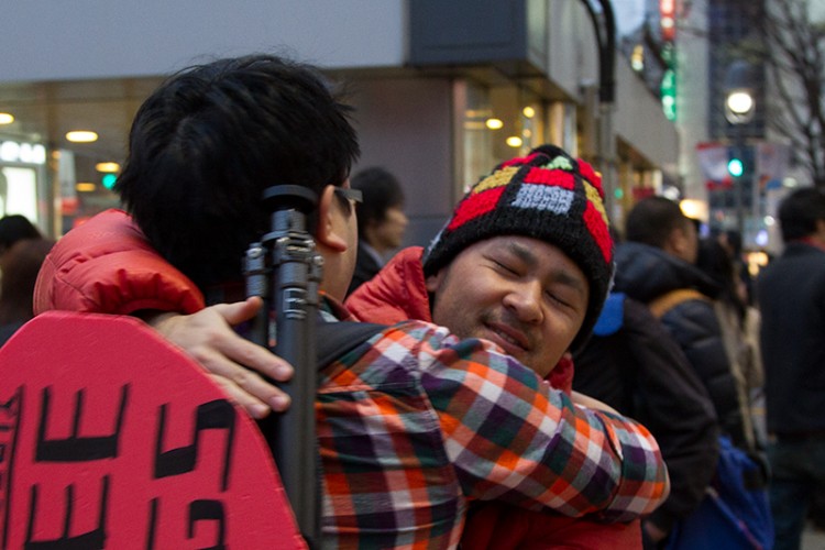 Two Japanese photographers sharing a hug