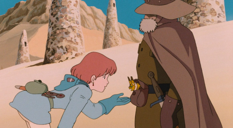 Nausicaa holding her hand out to a small animal