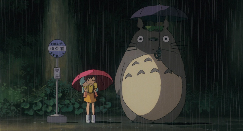 Girls and Totoro standing in the rain by a bus stop