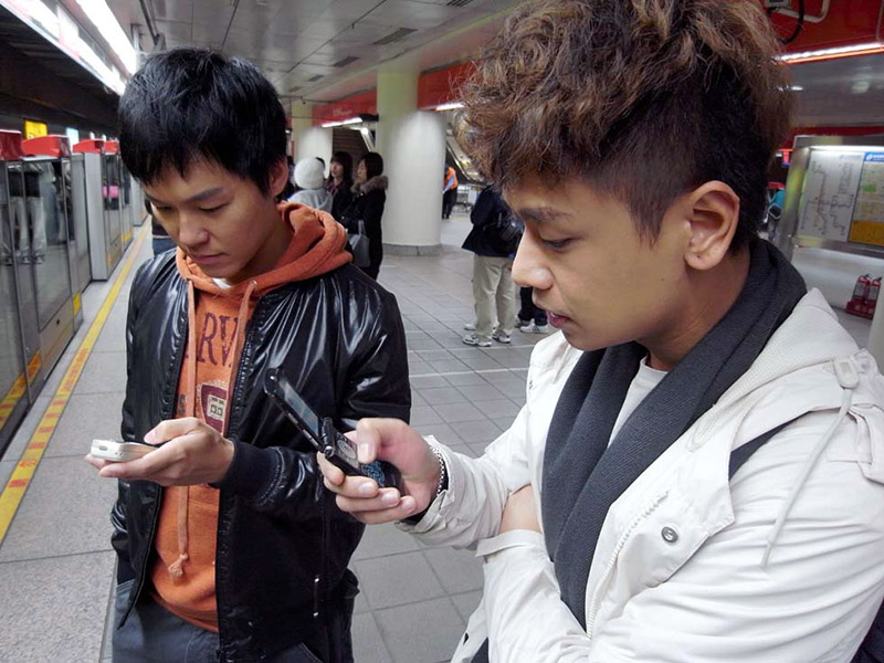 Two men looking at their cell phones