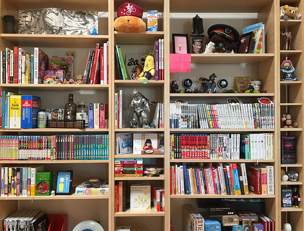 crowded bookcase filled with books about japan