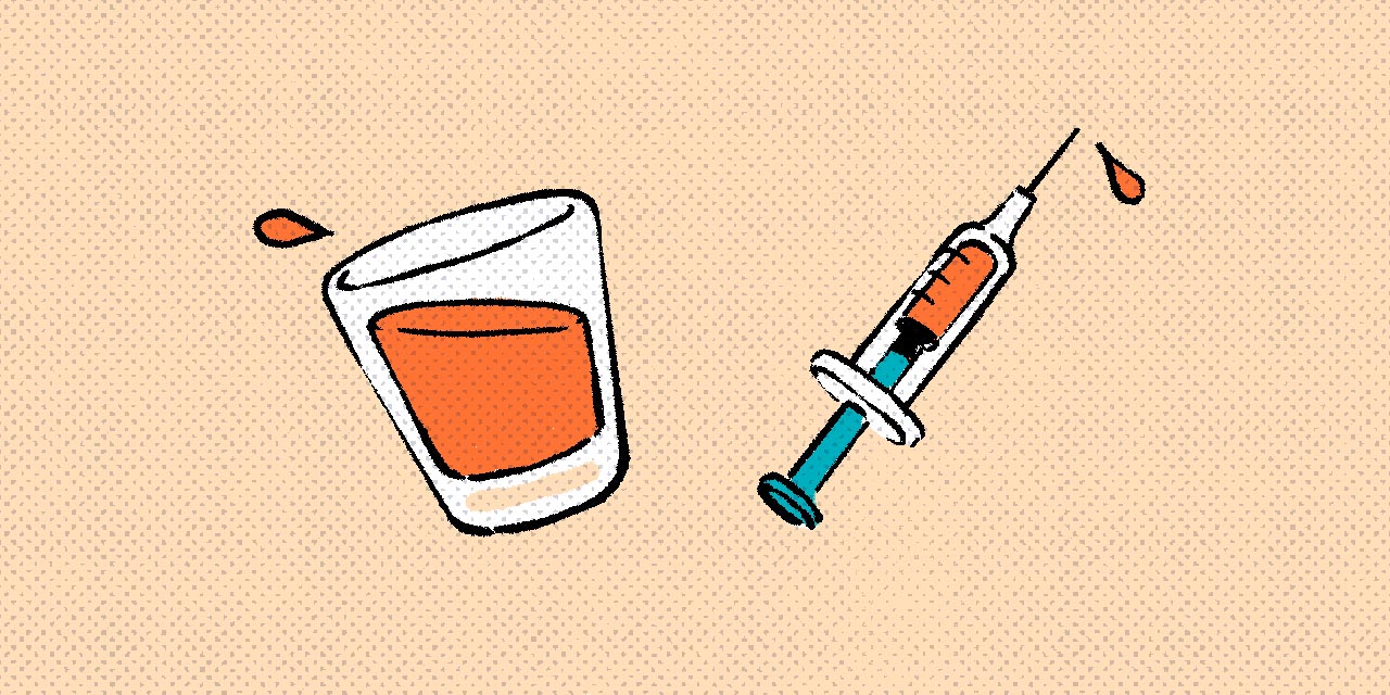a shot glass of alcohol and needle filled with fluid
