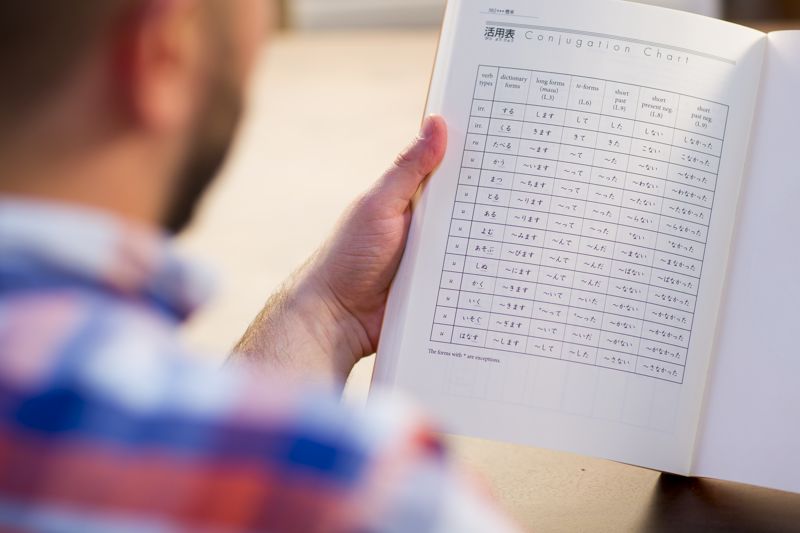 man holding book with chart on page