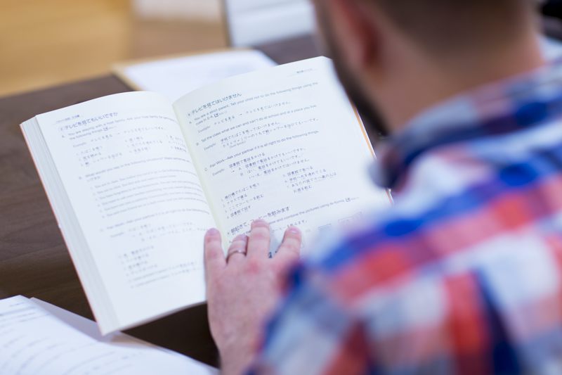 man reading genki textbook