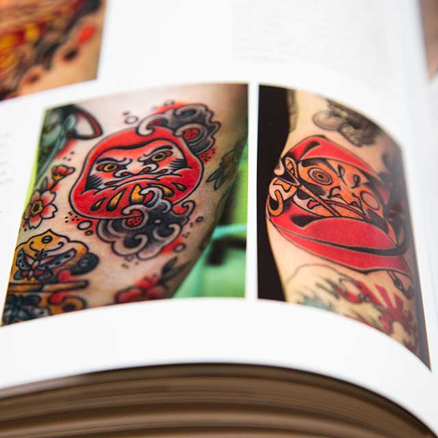 two daruma tattoos in a book