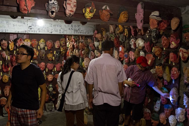 people exploring a room full of masks