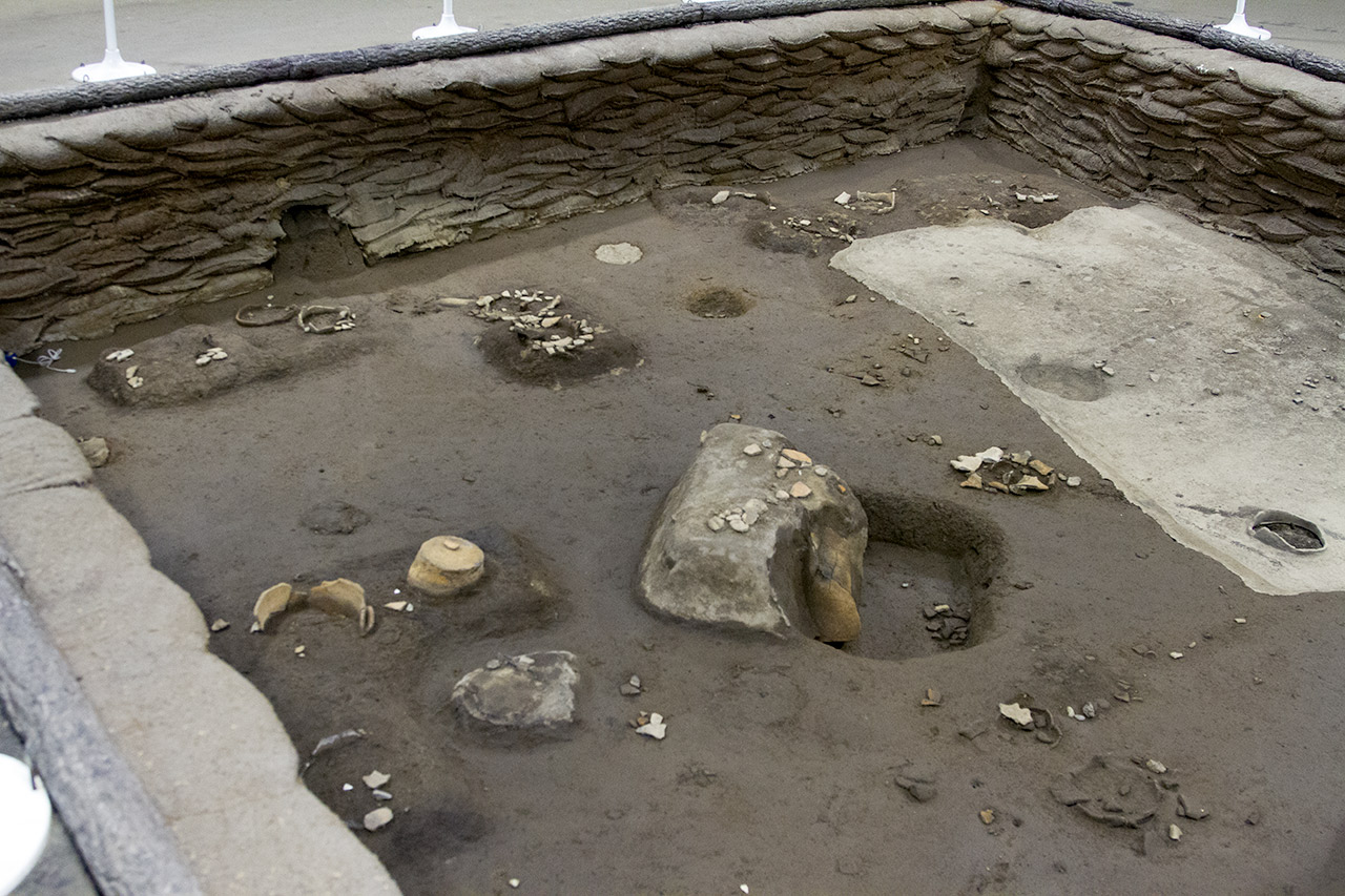 excavated pit with bone and pottery fragments