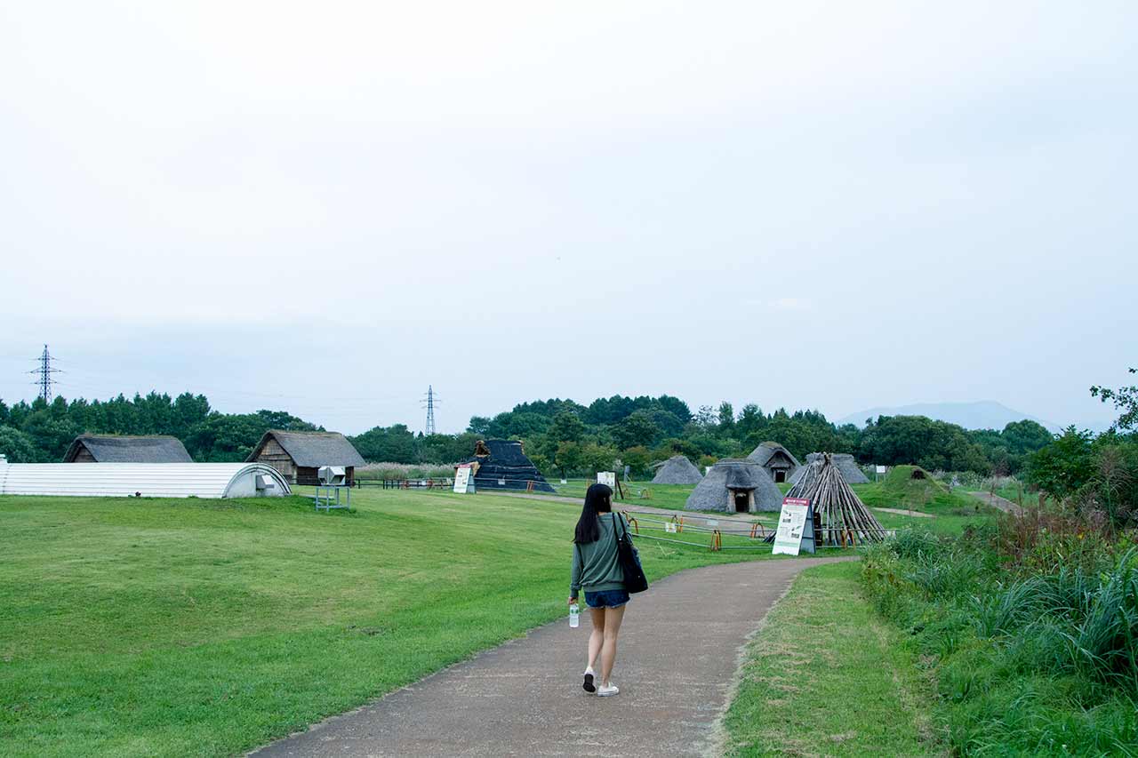 woman walking down path towards village