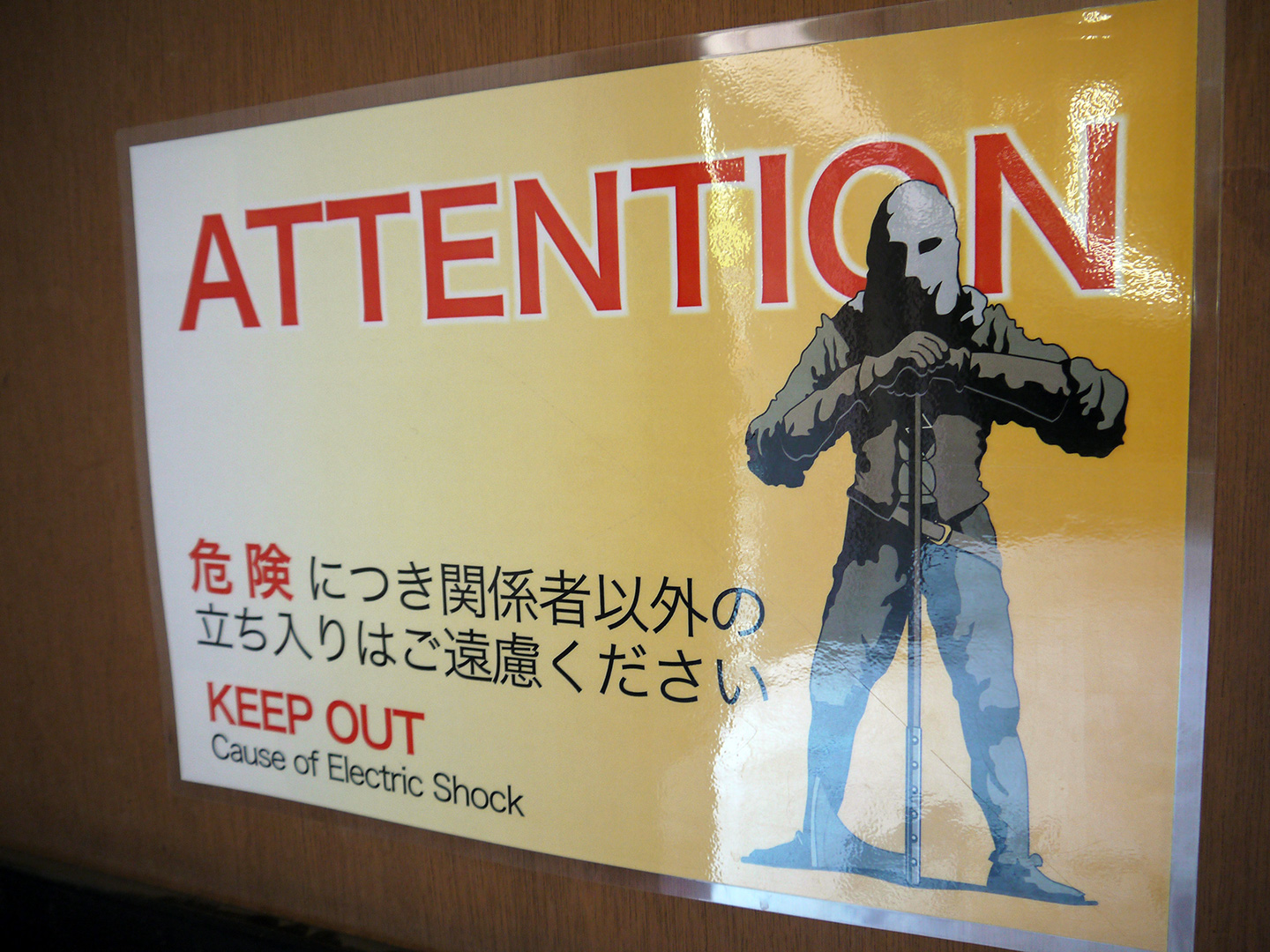 warning sign with picture of menacing hooded man