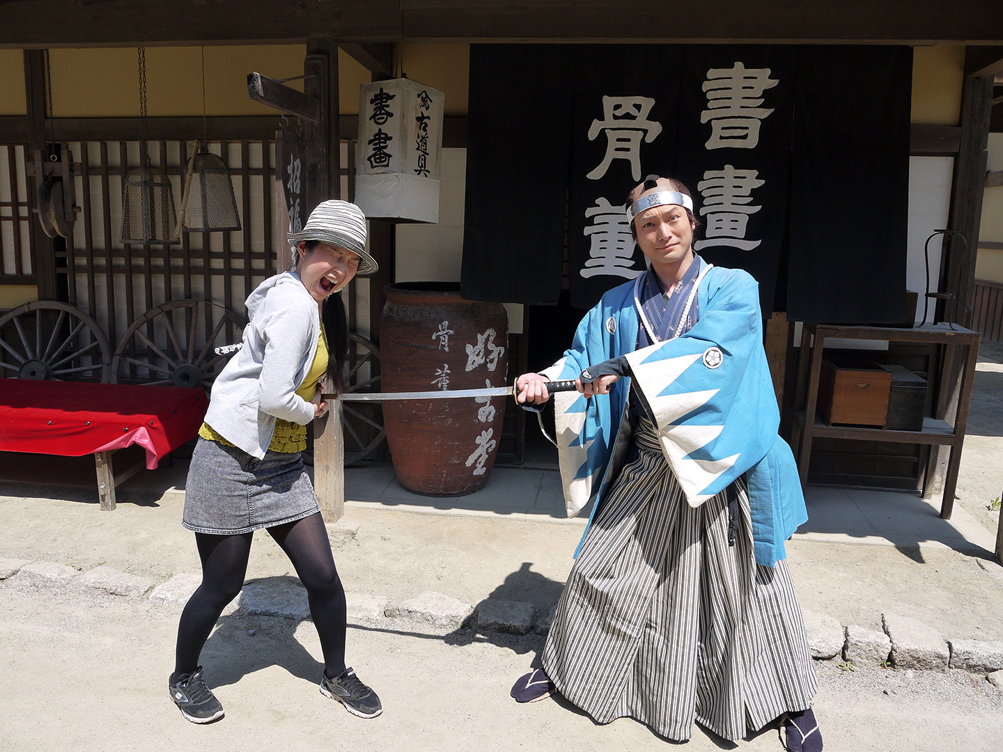 samurai pretends to stab woman with his sword