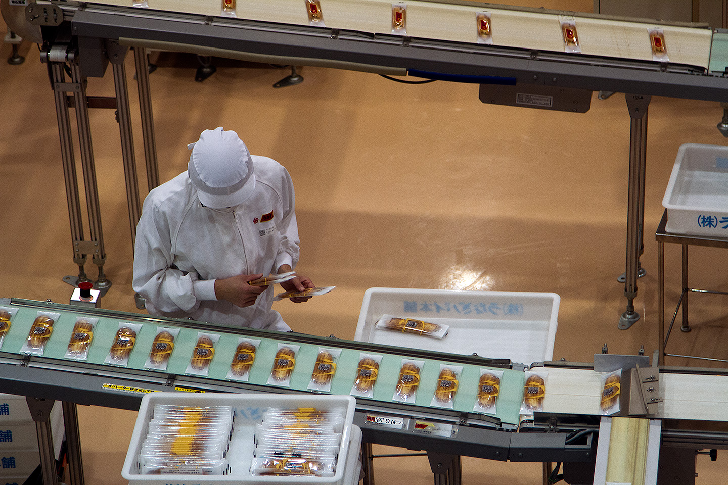 worker inspecting unagi pies on the assembly line