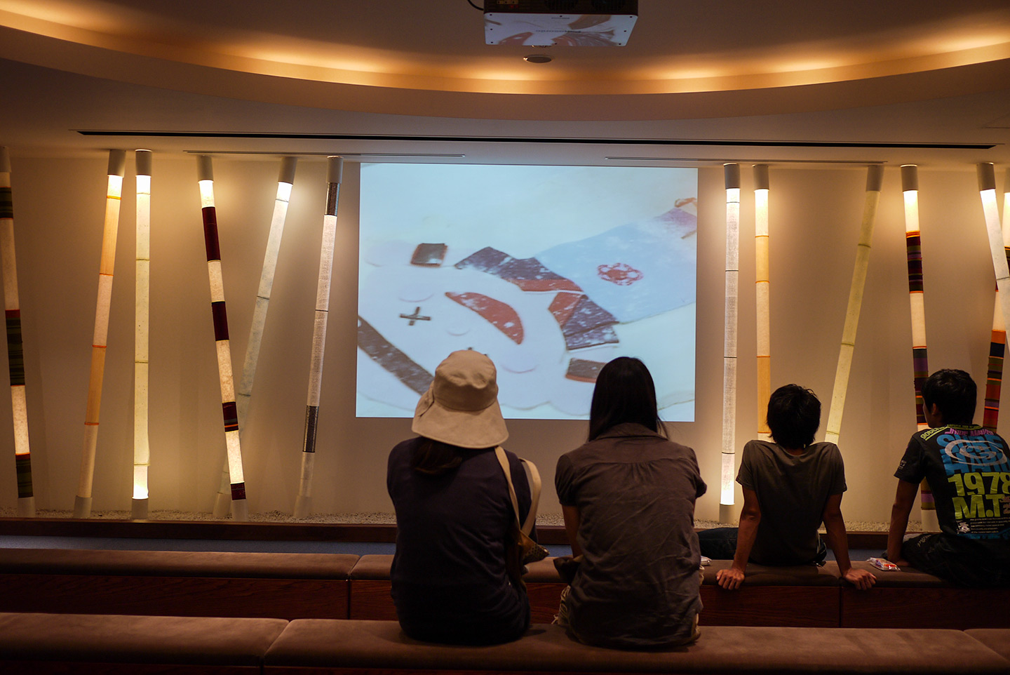 tourists watching video of factory history