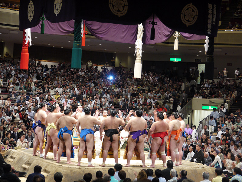 sumo wrestlers in a circle facing each other