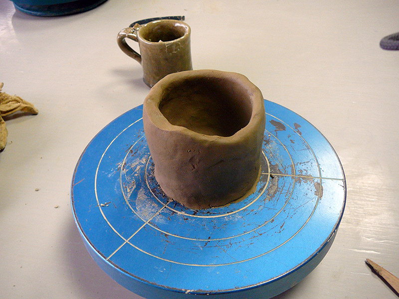 shaping clay on a pottery wheel