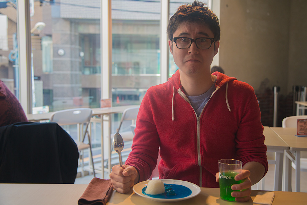 Koichi about to eat the plate of blue curry