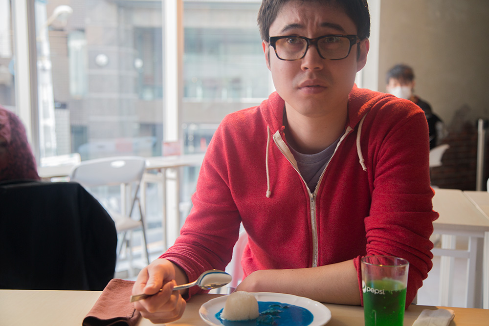 Young man grimacing with blue curry