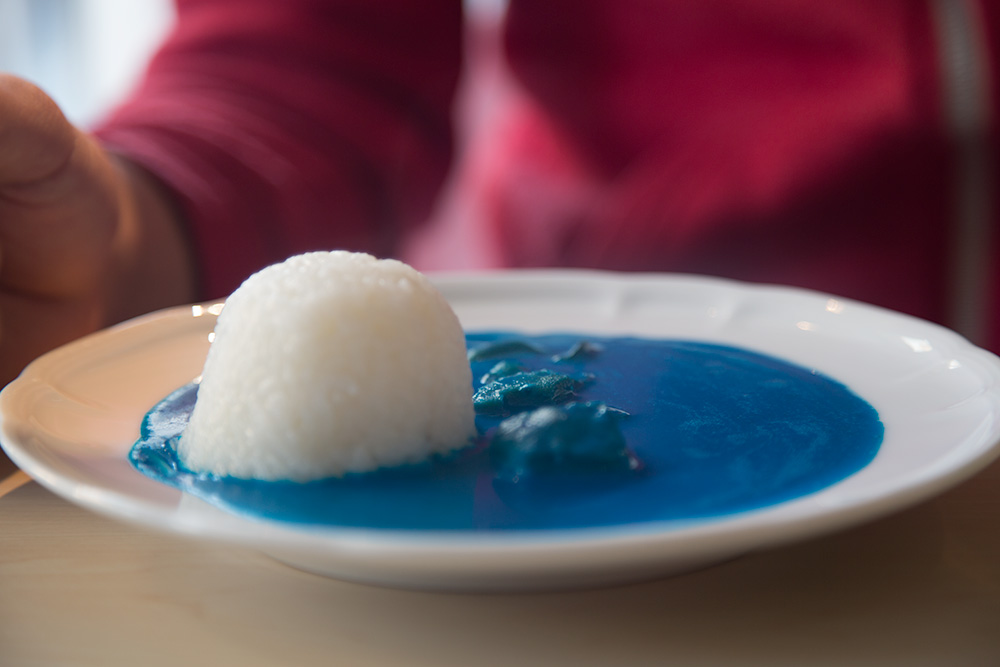 A plate of rice and blue colored curry