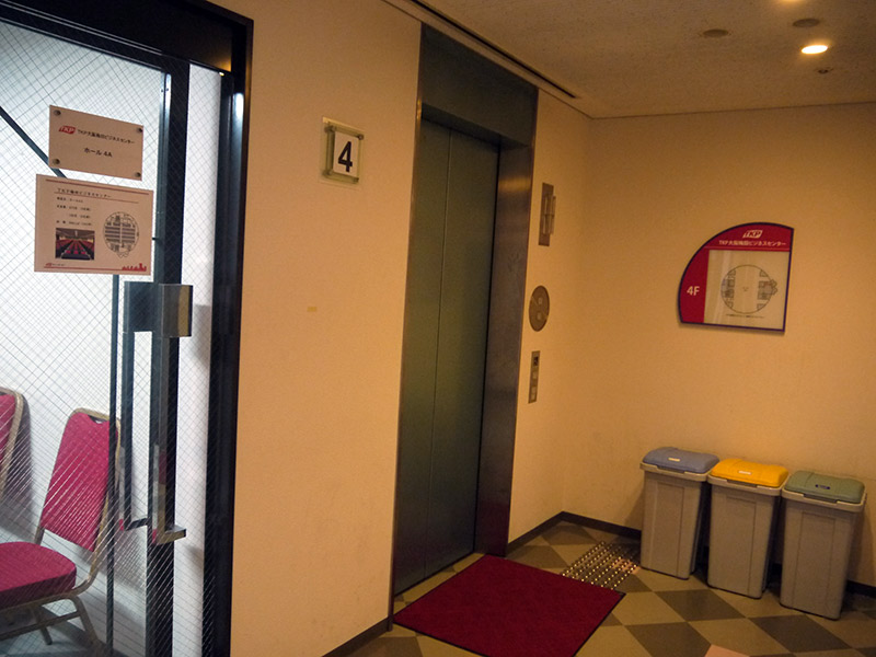 4th floor elevator and trash cans inside the building