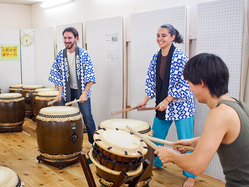 two foreigners learning taiko japanese drums in kyoto