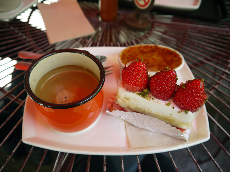 strawberry shortcake rectangle and red cup of coffee at cake shop