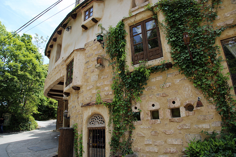 ghibli fairy tale village building with ivy and stone