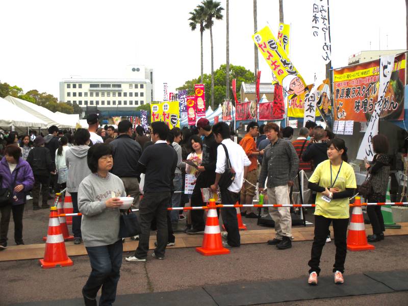 woman walking with bowl or ramen festival japan