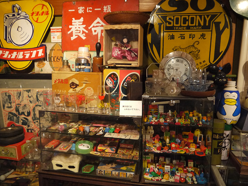 Vintage toys in glass cases and tin signs