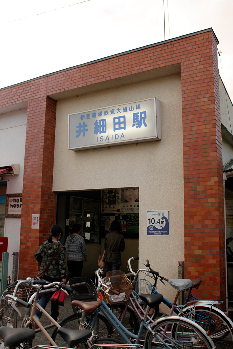 The outside of Isaida Station. An informational plaque about wave heights is posted on the wall.