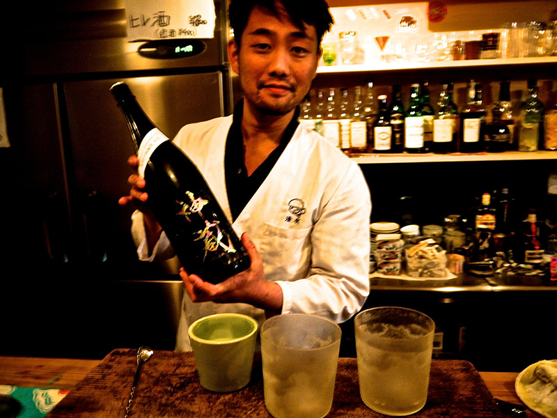 bar proprietor holding large bottle