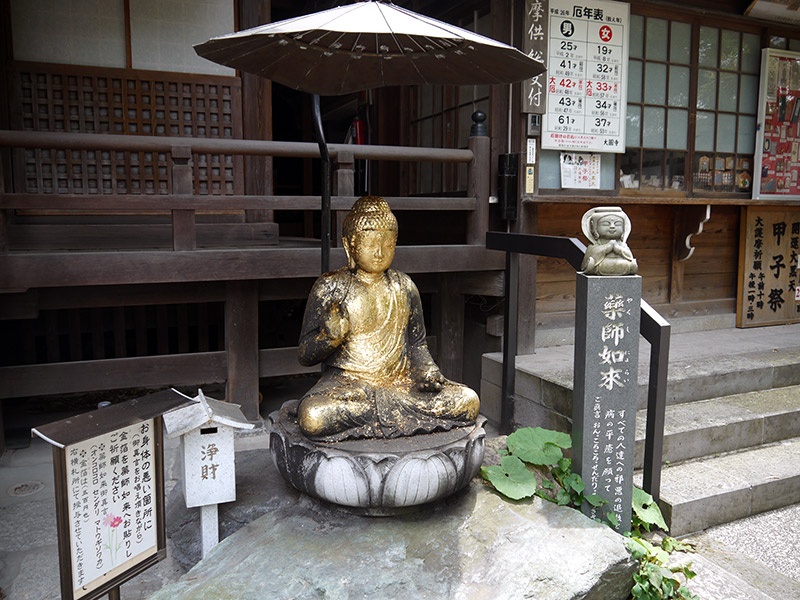 japanese shrine statue of the buddha covered in gold leaf