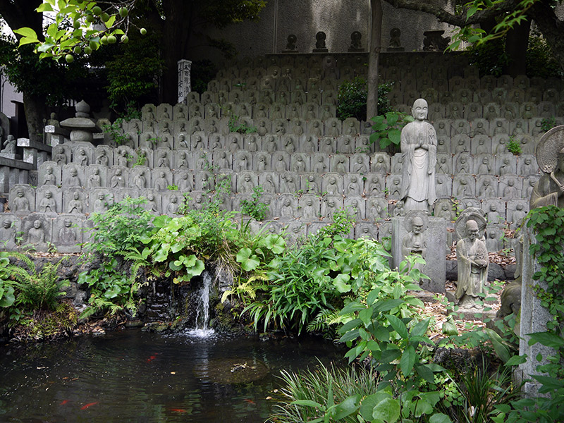 many other buddha statues stone statues all lined up