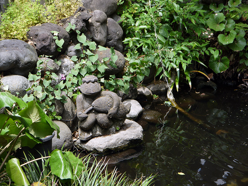 small stone sculpture in a pond garden