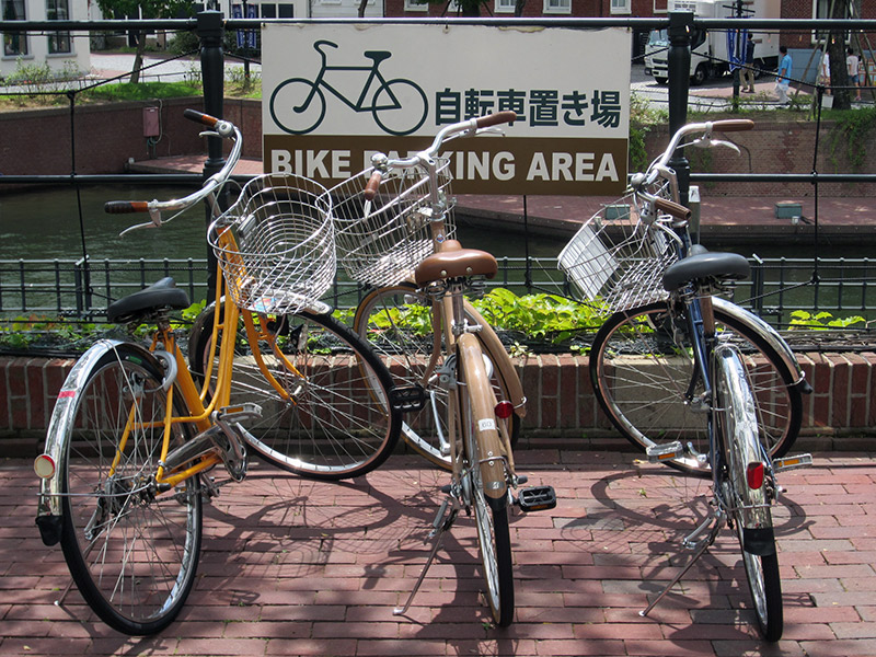 three bicycles in front of a bike parking area japan