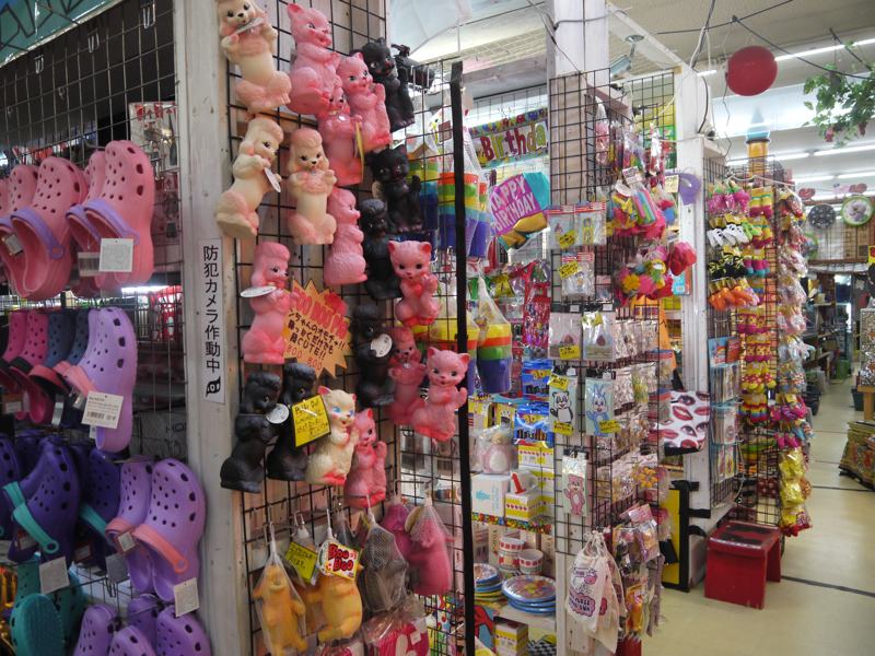 pink crocs and plastic pink kittens hanging in a store