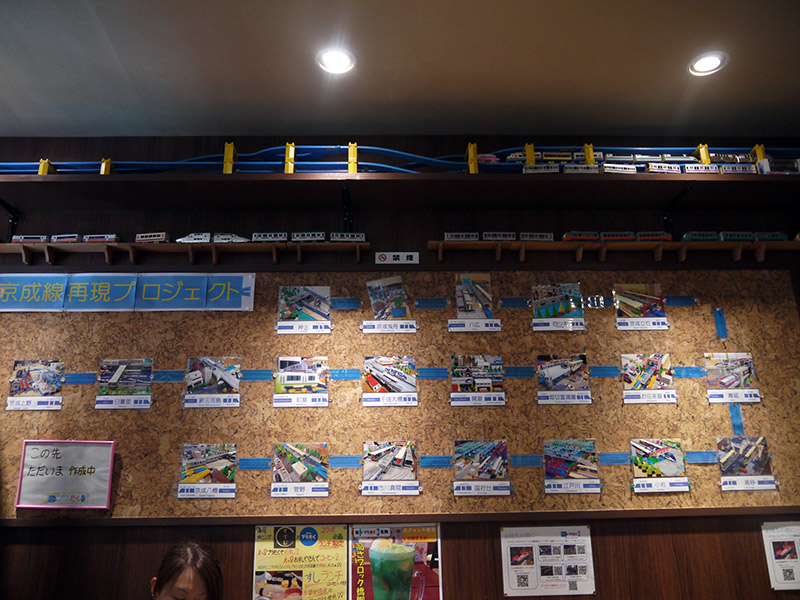 A bulletin board with various Plarail train models