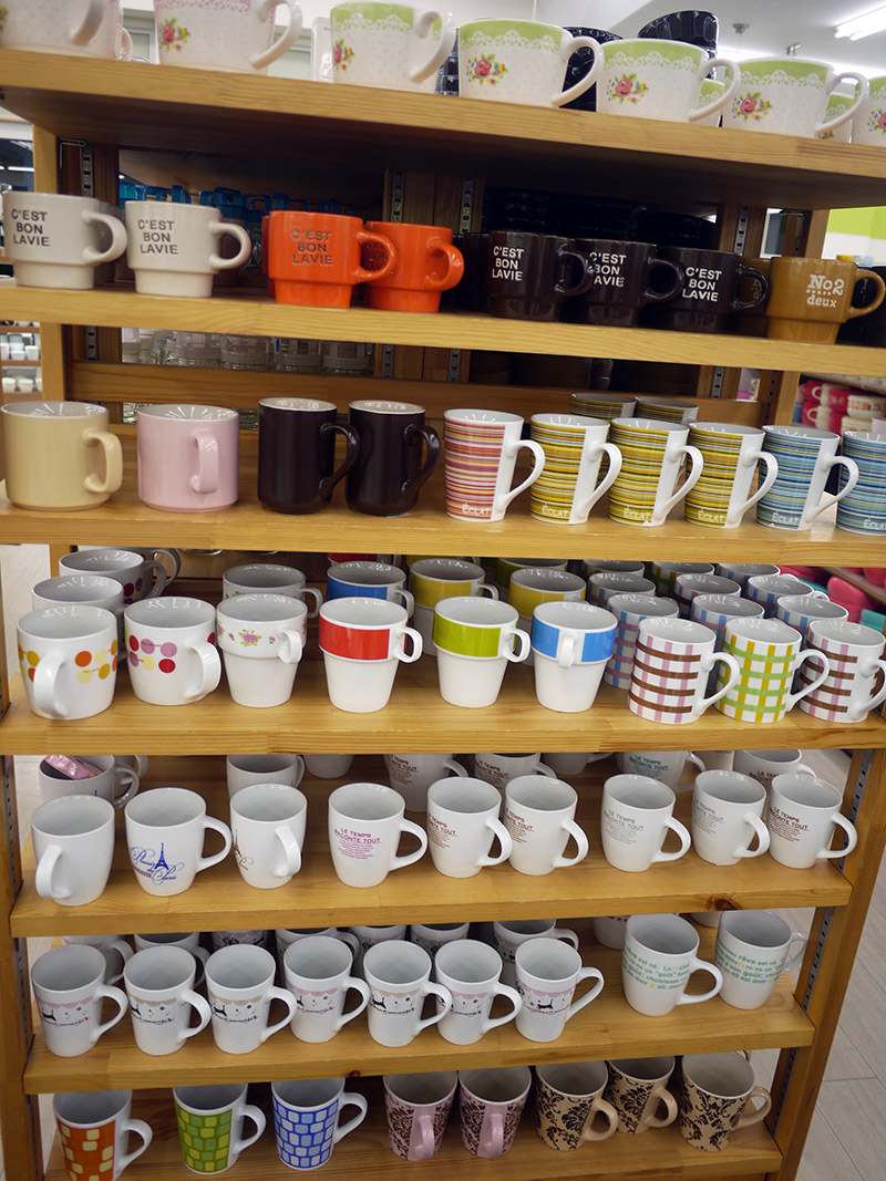 Colorful mugs in solid colors and prints on a shelf