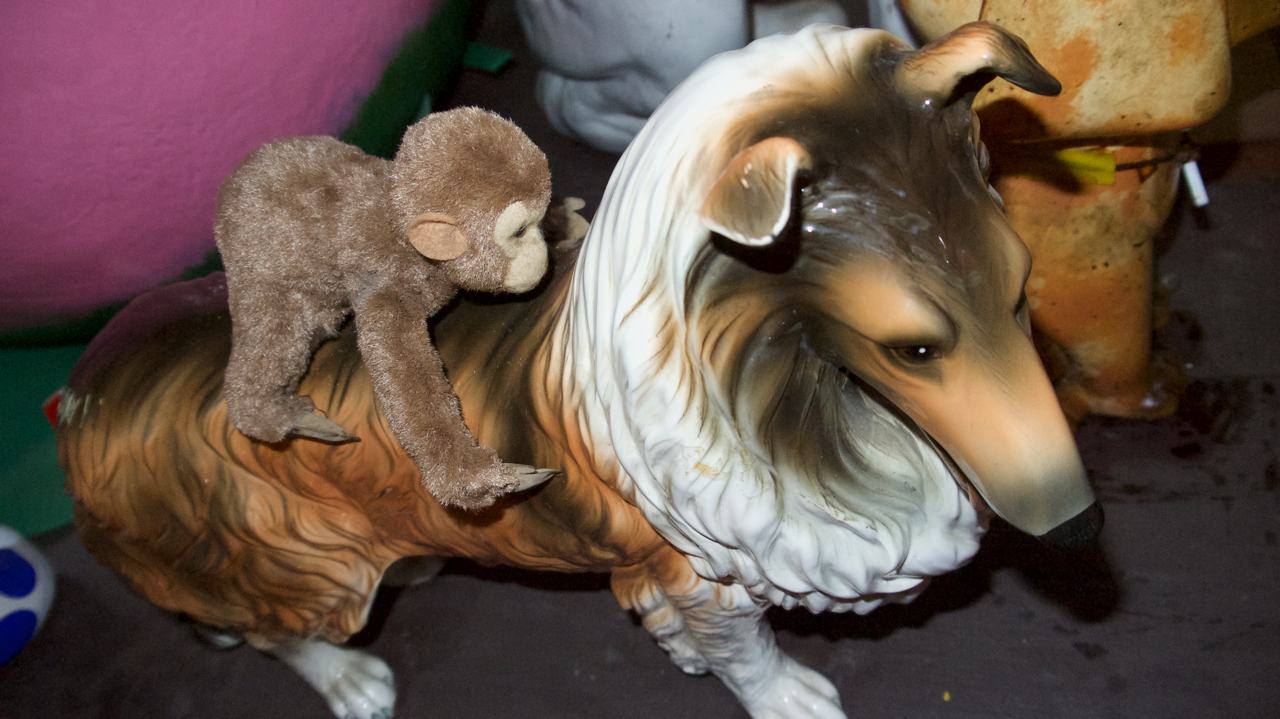 collie statue with monkey plush