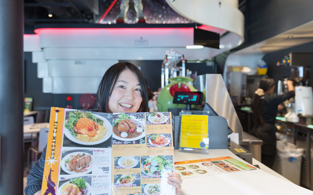 woman holding up menu from gundam cafe akihabara