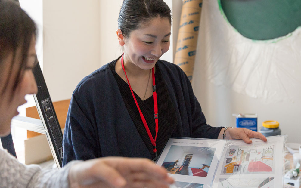 japanese artist holding a book of her work