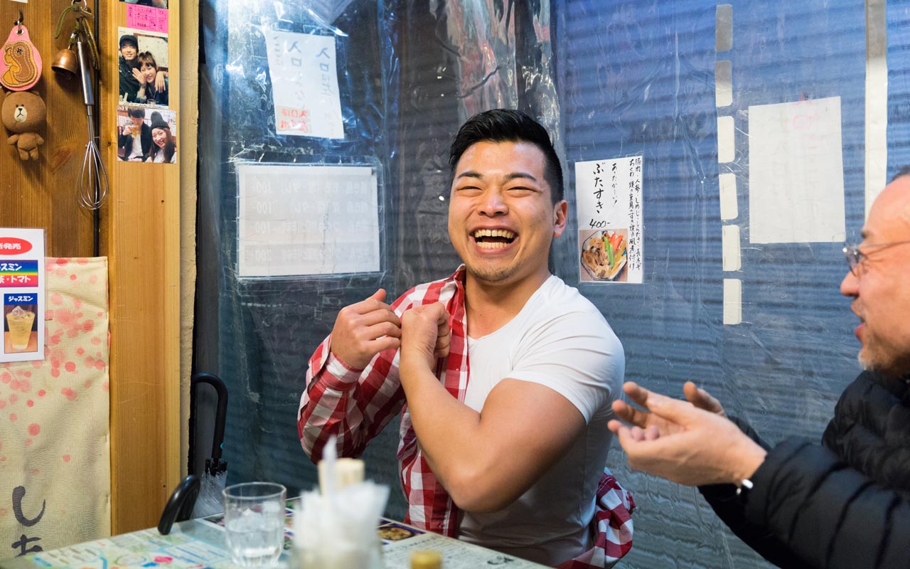 japanese man laughing in harmonica yokocho bar