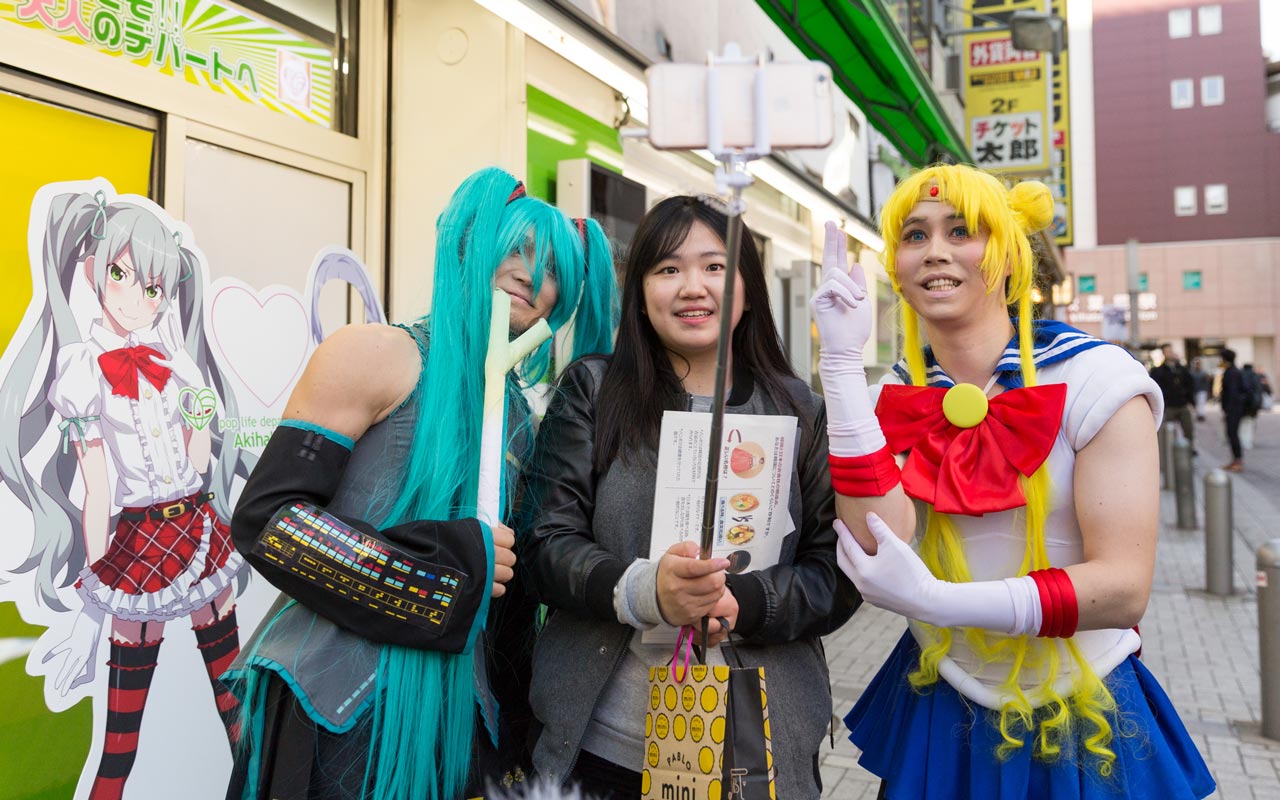 two men in cosplay posing with woman on street