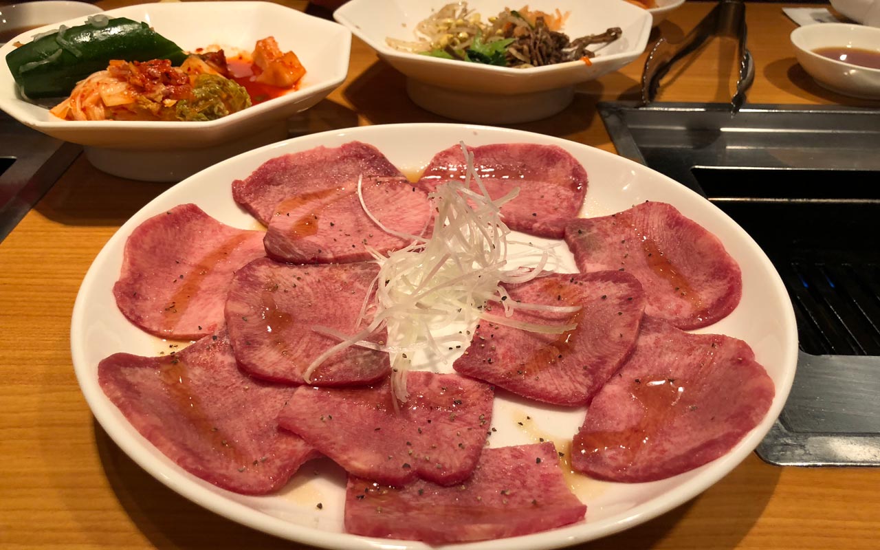 plate of raw beef tongue with shredded onion