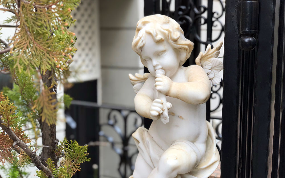 statue of a cherub playing flute