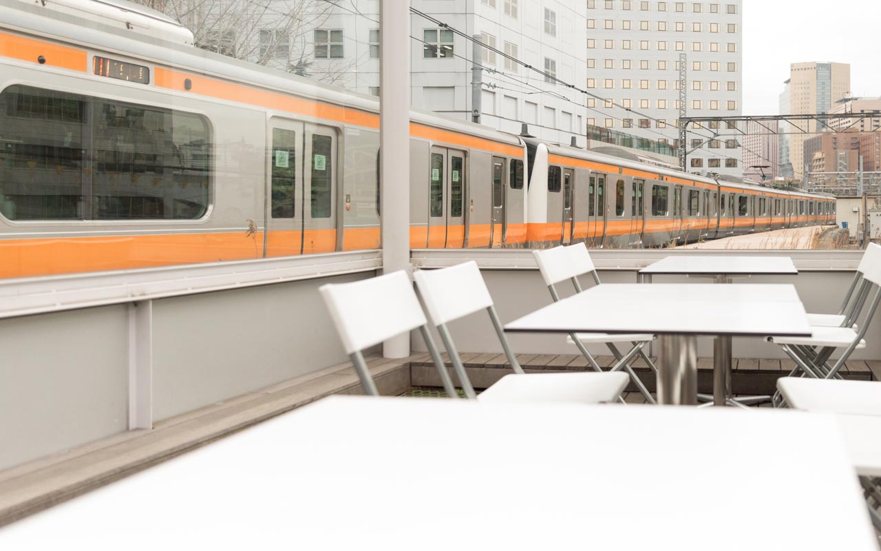 chuo line train passing by maach ecute observation deck