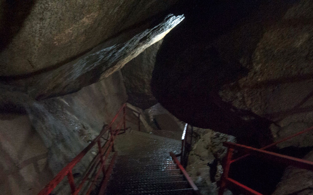 stairs and red railing leading into cave