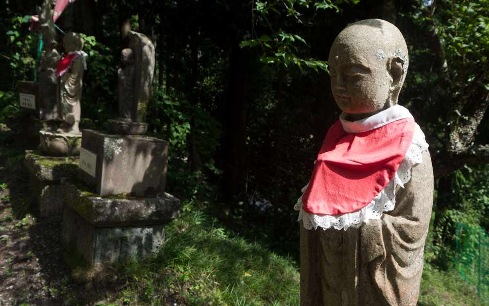 three jizo statues wearing red bibs